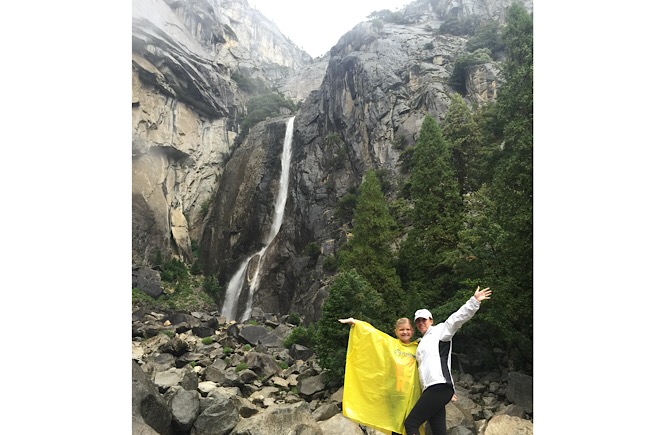 Yosemite Falls at Yosemite National Park- mother and daughter pictured in a yellow poncho