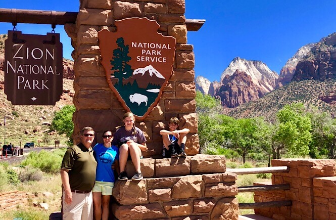 Top US family travel blog, More than Main Street, shares the ultimate 2 week Utah Arizona road trip itinerary; Zion National Park entrance/ sign.