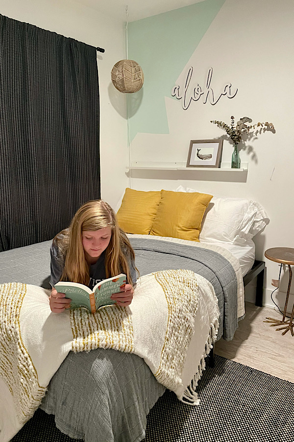 Guest bedroom with teenage girl reading at The Saturday House Airbnb in the Outer Banks.