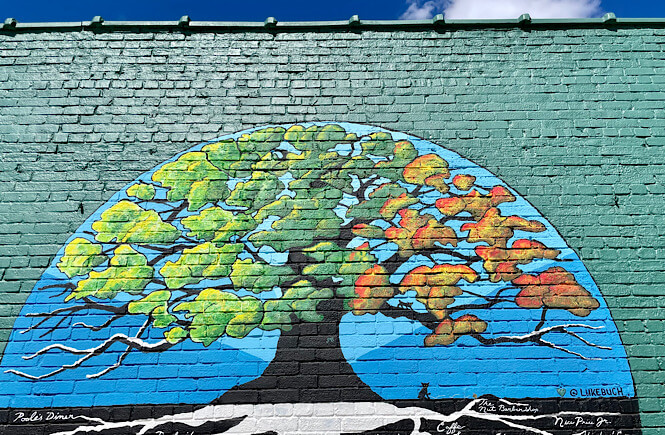 Raleigh city of oaks mural next to the All are Welcome mural in downtown Raleigh.