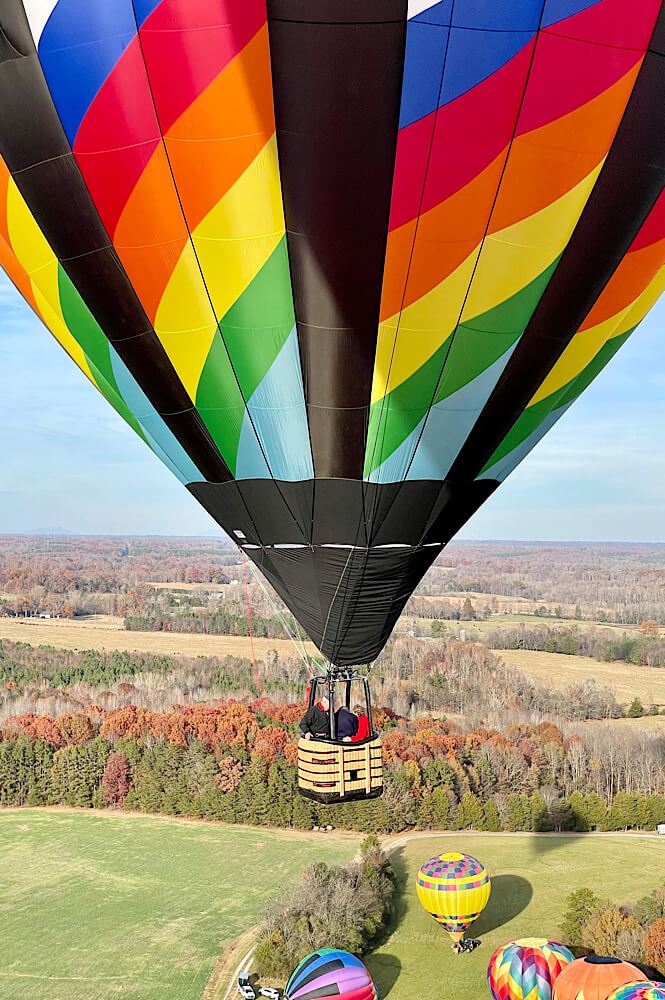 A colorful hot air balloon floating over Statesville NC during the fall.