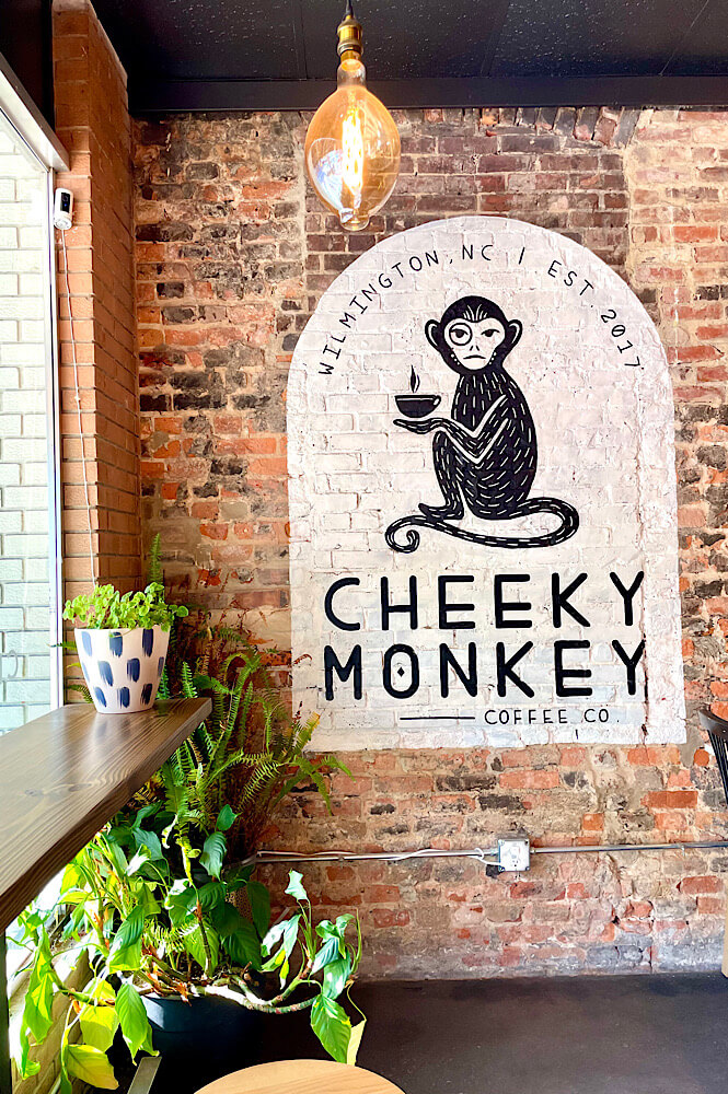 the inside wall of the Cheeky Monkey Coffee Shop in Wilmington NC has a bar and a mural with a monkey