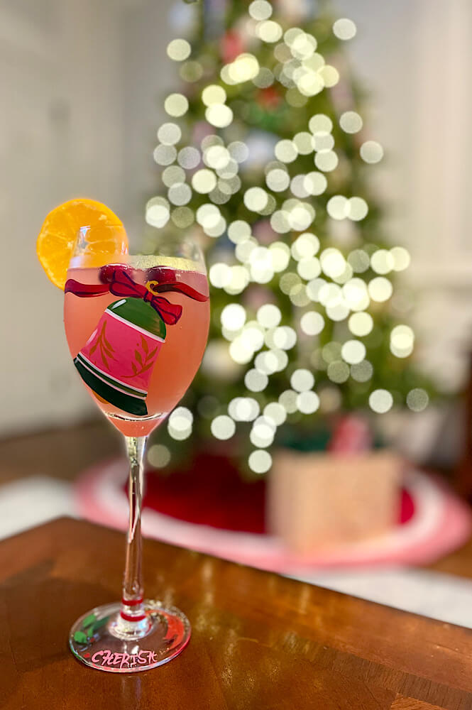 Wine glass with Christmas decor and tree in the background