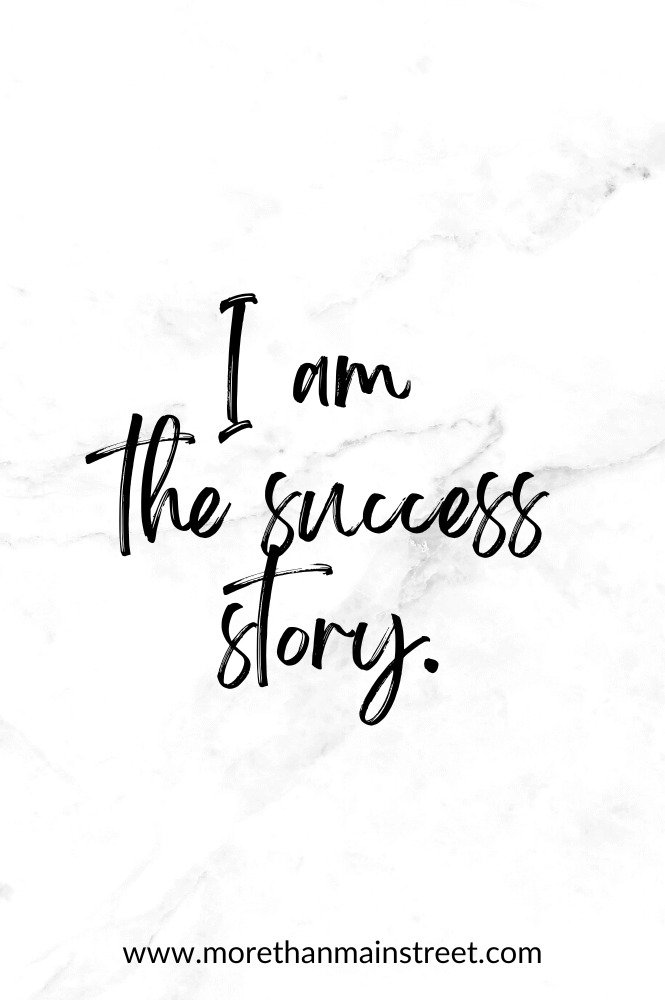 I am the success story- affirmation in handwriting font on white marble background.