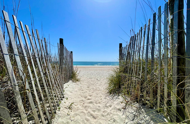 beach access at Wrightsville Beach NC: sand walkway with wooden fences on either side