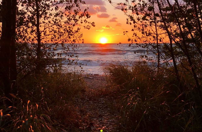 One of the best Pennsylvania road trips includes a stop at Presque Isle Beach at sunset