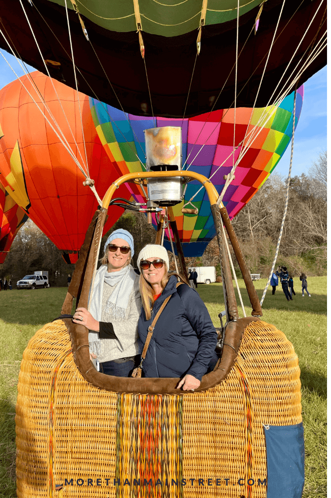 two women in the basket of a hot air balloon about to take off on a cold fall day