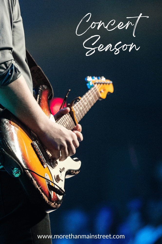 Concert season (image of a man holding a guitar at a concert)