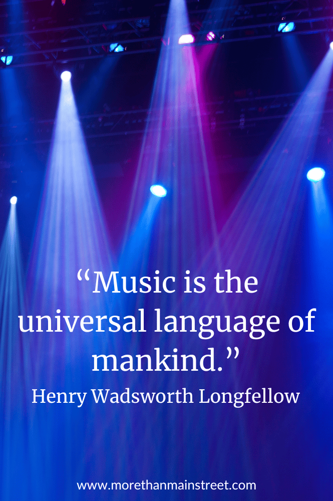 Music is the universal language of mankind. Concert quote with image of stage lights in blues and purples.