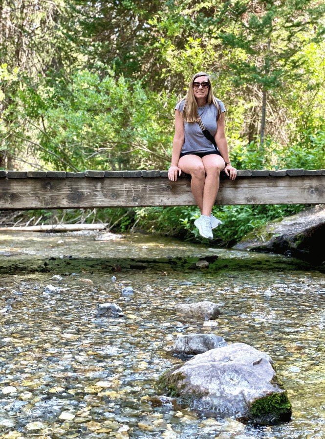 girl sitting on a bridge while hiking in utah
