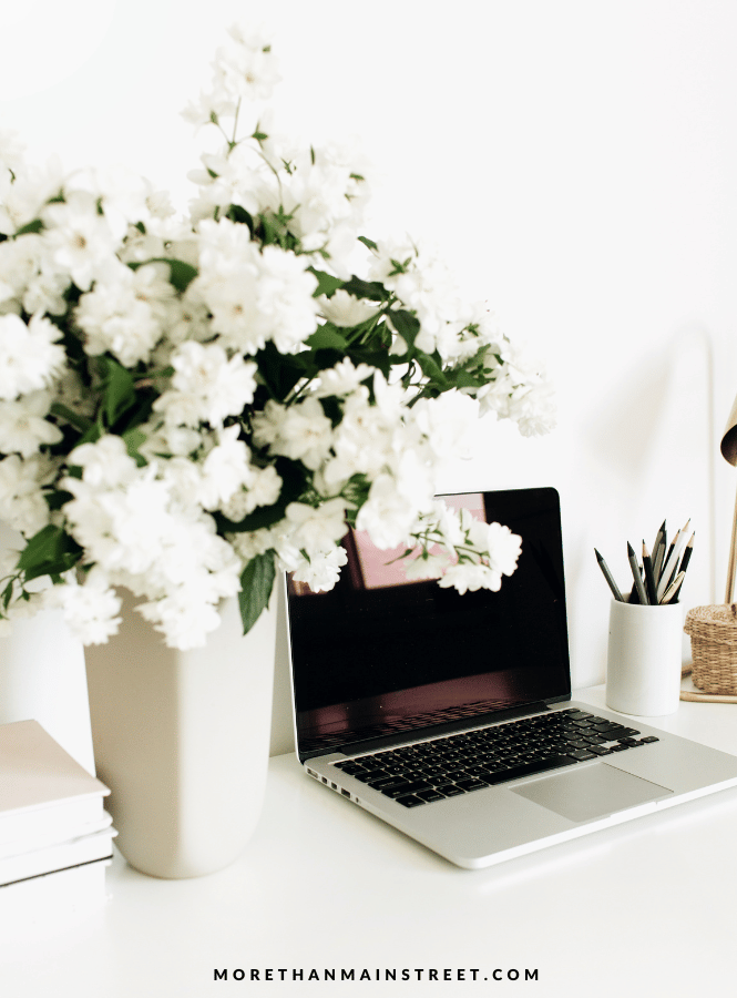 wellness wednesday at work-image of fresh flowers next to a computer and pencil cup