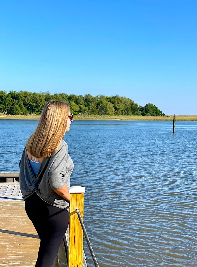 Mindfulness activiities can be as simple as taking a few deep breathes or just taking in the scenery around you like this woman standing on a dock by the water looking into the distance.