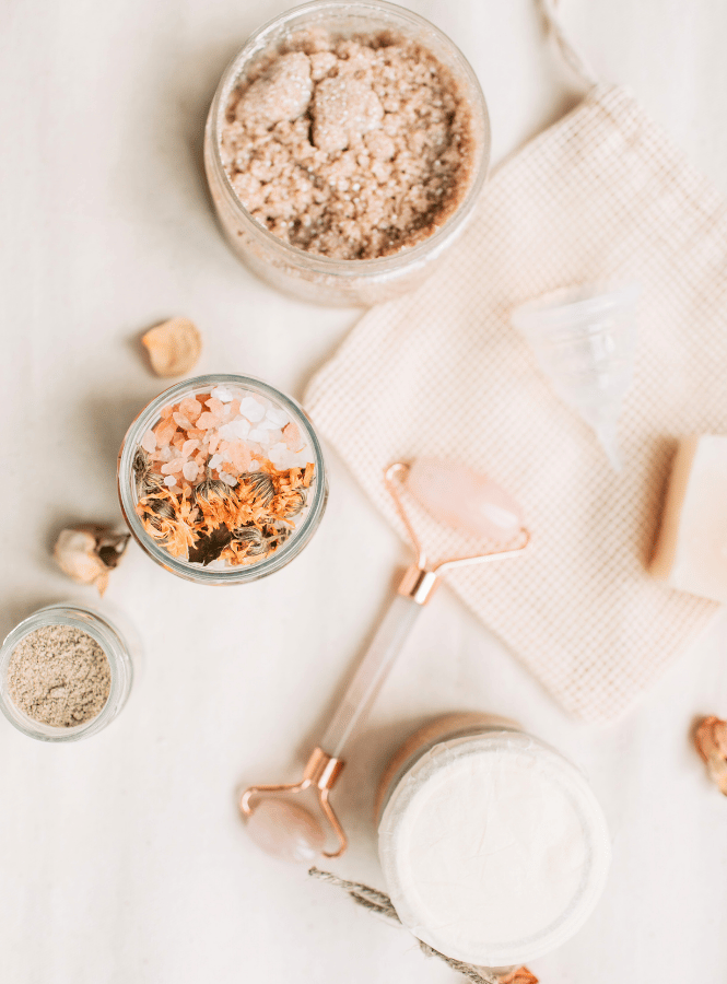 Revamp your skincare routine as part of your winter self care- image of skin care products like a face roller and sugar scrub.